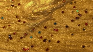 Akışkan renk. Şenlik sanatı. Yaratıcı tasarım. Altın parıldayan sıvı boya, makroda yüzen renkli tinler..
