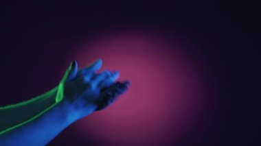 Bravo alkış. Vücut jesti. İyi ifade ettin. Tanımlanamayan bir kadın neon ışıkta el çırpıyor koyu mor arka plan fotokopi alanı.