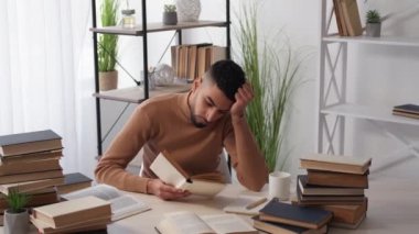 Sınav hazırlanıyor. Bitkin bir adam. Ev ödevi. Kitap okuyup el üstünde uzanan yorgun bir adam masa lambasının içinde uyuyor..