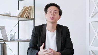 İş videosu. Çevrimiçi koçluk. Mesafe sunumu. Kendine güvenen başarılı erkek lider modern ofis içinde selamlaşarak selam veriyor. Uzun video çekimi.