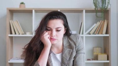 İş yorgunluğu. Sıkıcı bir röportaj. Verimsiz çevrimiçi konferans. Yorgun, uykulu iş kadını ofis içini dinlerken başını sallıyor. Uzun video çekimi.