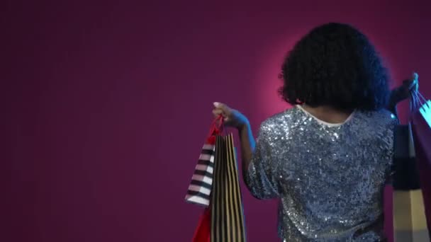쇼핑하는 알아볼 수없는 숙녀가 보라색 네온사인등을 배경으로 가방을 — 비디오