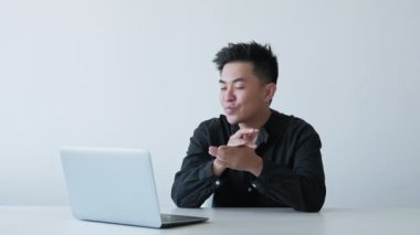 Çevrimiçi çağrı. İnternet toplantısı. Uzaktan iletişim. Beyaz fotokopi arkaplanındaki dizüstü bilgisayarla projeyi tartışan neşeli bir adam. Uzun video çekimi.