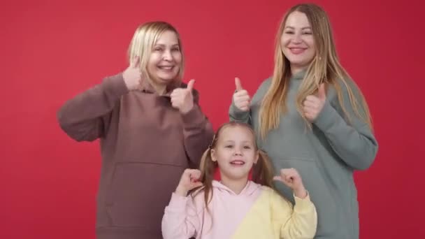 幸せな家族だ 応援サインだ 女性世代 かなり興奮した女の子ポルノのとともにお母さんとおばあちゃんショーのようなジェスチャーオン赤背景 — ストック動画