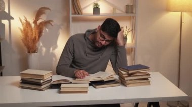 Sıkı eğitim. Sıkıcı adam. Bilgi çalış. İlgisiz bir adam masaya yaslanmış kitap aydınlatma odasının sayfalarını devralıyor..