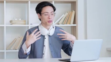 Çevrimiçi görüşme. Sanal toplantı. Mesafe iletişimi. Dijital ofisteki laptopla selamlaşıp selamlaşan neşeli adam. Uzun video çekimi.