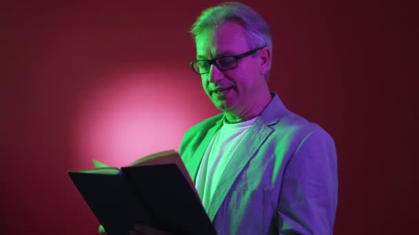 Zajímavá Kniha Starší Muž Neonový Světelný Portrét Soustředěný Starší Muž — Stock video
