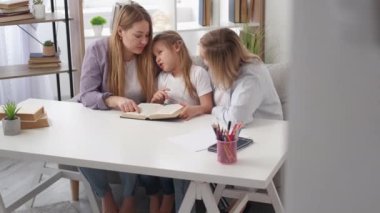 Ev ödevi. Okuyan kız. Sıkı eğitim. Annesiyle ve büyükannesiyle aydınlık odada kitap okumaya çalışan ilgisiz bir çocuk..