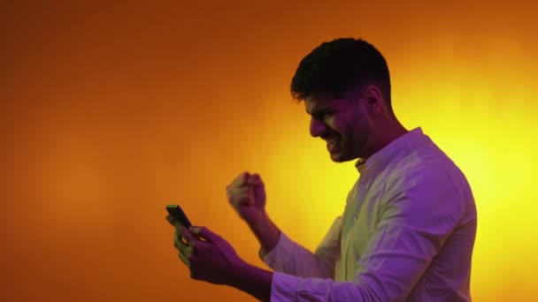 Online Spiel Siegermann Porträt Neonlicht Aufgeregte Kerl Suchen Handy Ausdrücken — Stockvideo