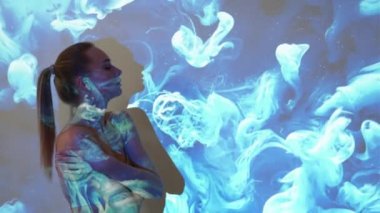 Huzurlu bir uyum. Sakin bir kadın. Kavramsal sanat portresi. Sakin siluet kadın çıplak iç çamaşırlarıyla mavi ışık gölge sıvısı üzerinde hareket ediyor arka planda çift pozlama.