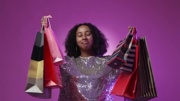 いい買い物だ 満足した女性だ 割引販売 幸せな女性ショー多くのカラフルな紙袋ポーズ赤紫ネオンライト背景 — ストック動画