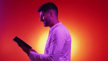 İlginç bir kitap. Mutlu profil adamı. Neon ışıklı portre. Mor arkaplan fotokopi alanında poz veren zarif bir adamdan esinlendim..