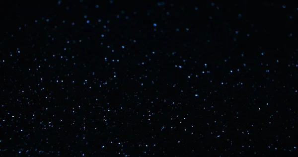 輝く背景 ボケのキラキラした食感 夜空の星 暗い黒の抽象的なフリースペースの壁紙に焦点を当てた青の色の光の反射 — ストック写真
