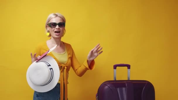 休暇の興奮 幸せな女性だ 旅のインスピレーション 中年正女性で夏ルックダンスとともに搭乗書類帽子上の黄色の背景スローモーション — ストック動画