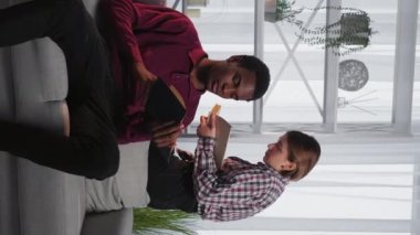 Dikey video. Evde eğitim. Okuma öğrencisi. Çeşitli insanlar. Ciddi siyahi erkek ve Avrupalı kadın kitap okuyorlar..