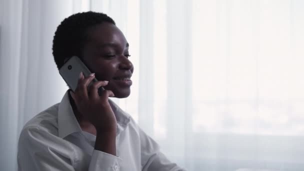 移动通信 商务电话 远程协议 信心十足的领导女性在电话交谈中谈到浅白窗口背景下的自由空间项目 — 图库视频影像