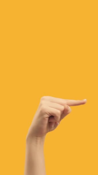 垂直录像 手指指向下一个 看右边 展示橙色空空间商业背景的新页面的女性之手 — 图库视频影像