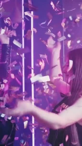 パーティーのお祝い 幸せな女性だ ナイトクラブの楽しみ 雨の中で踊る楽しい女性の友人紫色のネオンスローモーション 垂直ビデオ — ストック動画