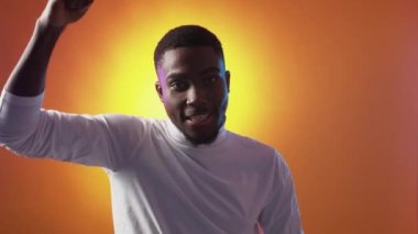 Fan support. Victory celebration. Champion league. Encouragement greeting. Excited proud satisfied man raising clenched fists on orange.