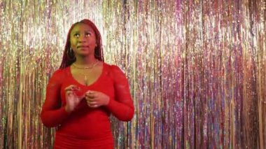 Rich party. Excited couple. Festive inspiration. Generous black man giving unlimited credit card to beloved woman embracing together on shimmering cascade curtain background.