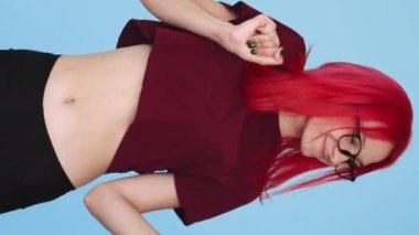 Vertical video. Winner dance. Success celebration. Positive lifestyle. Satisfied proud overjoyed girl having fun on blue background seamless loop.