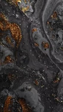 Vertical video. Sparkling fluid. Paint flow. Marble texture. Defocused shiny gray golden color oil bubble glitter texture ink mix wave motion abstract background.