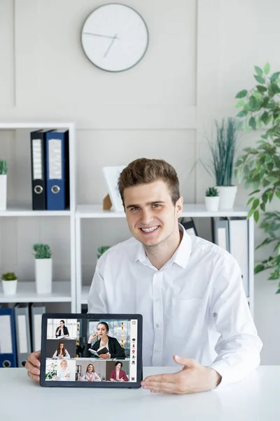商业网络研讨会 虚拟教练 网络会议 在办公室内部平板电脑屏幕上展示女性团队的自信而快乐的男人 — 图库照片