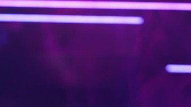 Color vapor. Neon light. Ultraviolet rays. Defocused purple lines glow smoke flow motion on dark abstract free space presentation background.