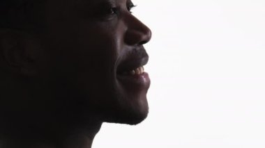 Happy man smiling face. Optimistic hope. Cropped closeup profile silhouette of cheerful inspired guy isolated on white empty space background.