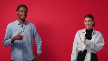 Successful result. Happy friends. Diverse people. Happy supportive man and woman showing like gesture thumbs up posing red background.