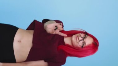 Vertical video. No gesture. Warning sign. Wrong choice. Skeptic girl peeking out showing denial finger wag on blue background seamless loop.