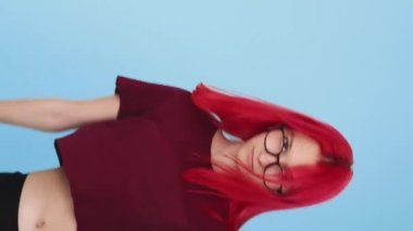 Vertical video. Fist warning. Punishment threat. Conflict fight. Grumpy angry girl showing punching gesture on blue background seamless loop.