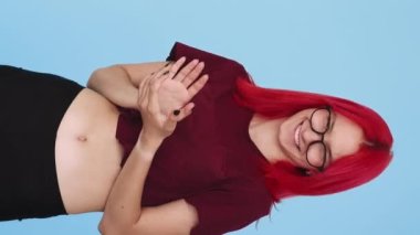 Vertical video. Congrats applause. Approval support. Praising admiration. Proud satisfied girl clapping hands on blue background seamless loop.