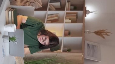 Vertical video. Remote job. Workaholic lifestyle. Freelance job. Tired overworked woman employee working online using laptop at home office workplace.
