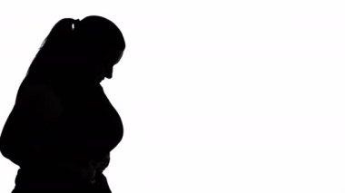 Depressed obesity. Female silhouette. Body shaming. Upset plus size profile woman retracting belly to become slim posing white background copy space.