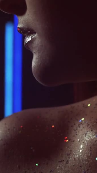 垂直ビデオ キラキラした肌 メイクアート ナイトクラブの様子だ ネオンブルーの赤い色の光の女性の顔とともに輝く金属シルバーリップオンダーク — ストック動画