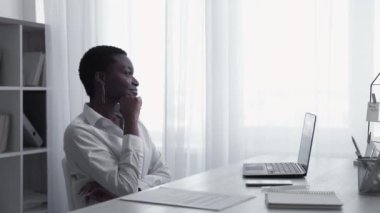 Creative work process. Idea development. Professional inspiration. Smart pensive business woman thinking working on project with laptop at light home office workplace.