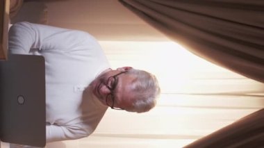 Vertical video. Internet addiction. Compulsive gambling. Family argue. Excited father playing online game angry son closing laptop stopping gadget dependency at home.