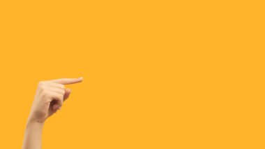 Recommending gesture. Right direction. Female hand finger pointing demonstrating blank area on orange empty space commercial background.