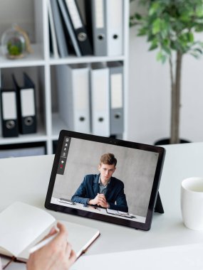Video interview. Web chat. Online conference. Internet meeting. Business people taking notes working online on tablet screen at digital office.