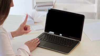 Online management. Video call. Internet conference. Business woman counting from one to five working on mockup laptop with copy space black screen.