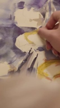 Vertical video. Artwork painting. Visual art. Hobby inspiration. Female artist hand creating yellow blue color abstract picture with wax crayon on paper.