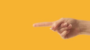 Hand pointing. Commercial background. Female index finger showing left demonstrating announcement on orange advertising empty space.