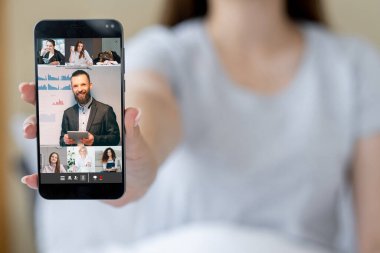 Online presentation. Video chat. Corporate telecommuting. Woman showing business team working online on phone screen on free space background.