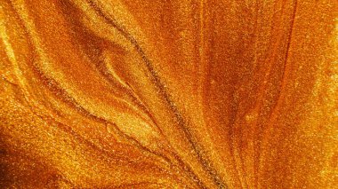 Glitter fluid. Abstract background. Desert sand. Defocused sparkling metallic orange golden yellow color grain paint wave texture with free space.