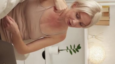 Vertical video. Virtual friends. Casual woman. Online connection. Happy middle-aged lady in home look having video conference on laptop light room interior.