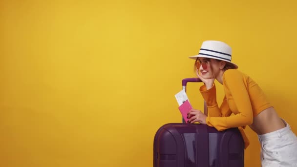 旅行离开 有灵感的女人广告背景 夏天快乐漂亮的女士靠着手提箱 在黄色的复印室里拿着登机牌 — 图库视频影像