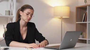 Project difficulties. Desperate woman. Work problem. Upset tired lady worried about result working laptop sitting in light office room interior.