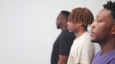 Hipster black men. Concentrated look. Profile portrait. Serious guys staying in line looking straight posing light background defocused copy space.