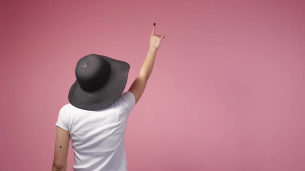 見えないテキスト 女性旅行者 出発予定 認識できない女性で夏の帽子指すコピースペース移動指上のピンクの広告の背景 — ストック動画